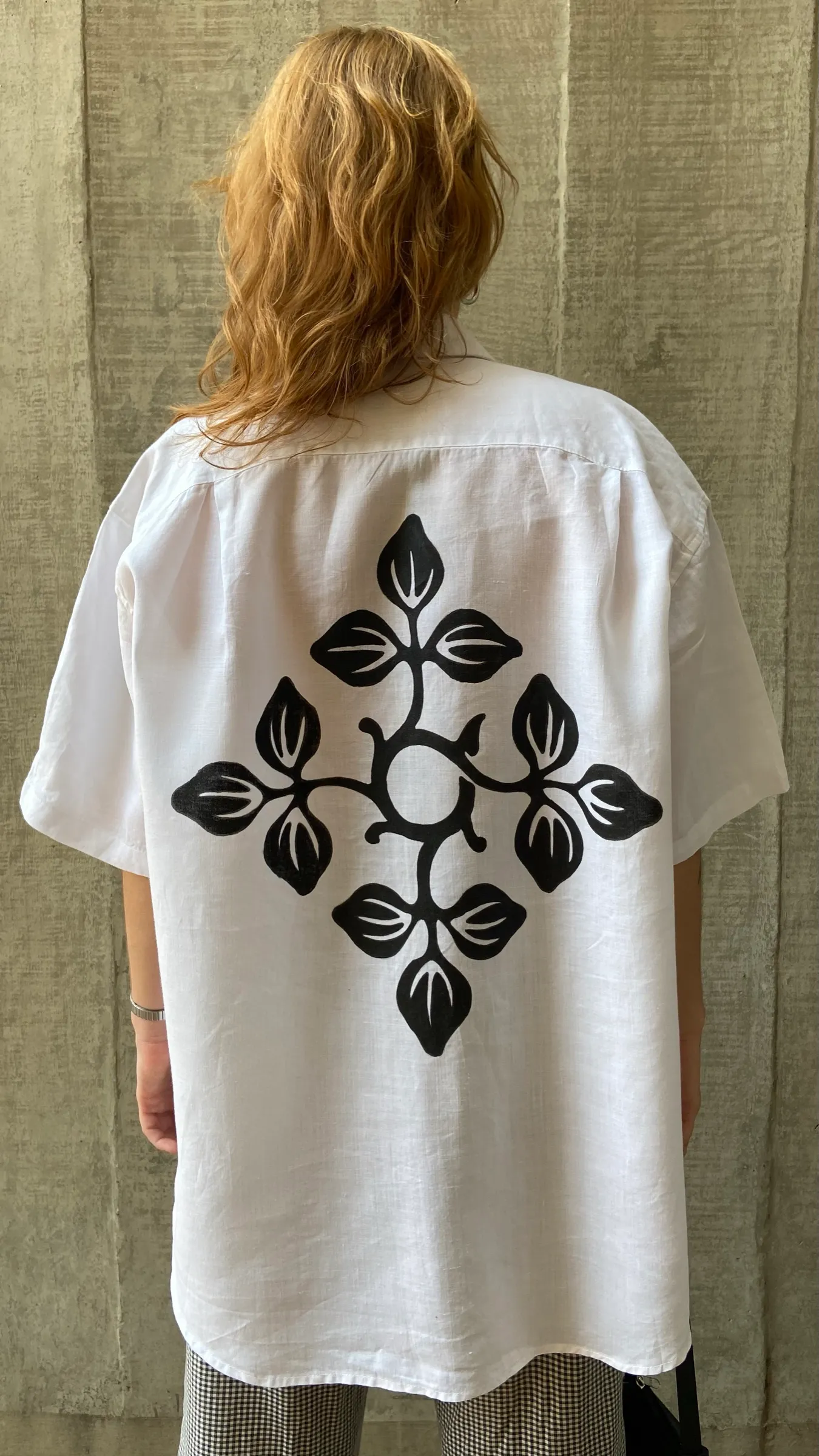 Back of a white shirt printed with a black floral illustration